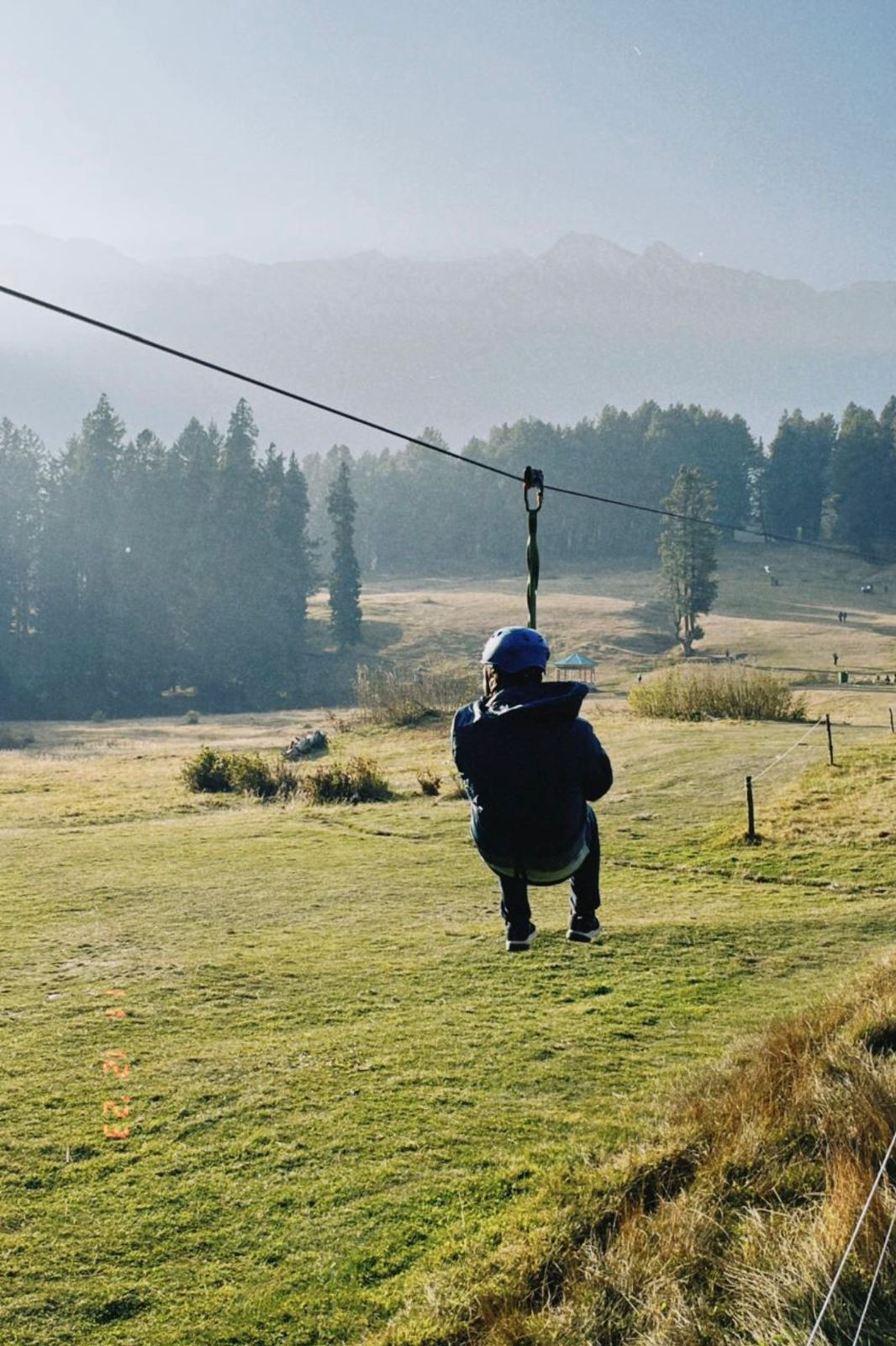 Now a common sports, a man doing zip lining in the valley of Kashmir.