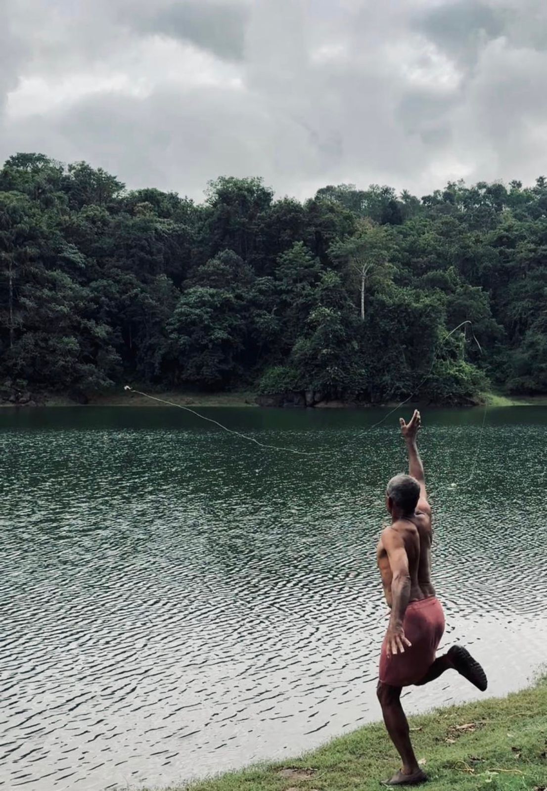 A man fishing in the waters of Kerala, India.